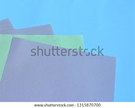 White and colored sheets of paper on white background. Cool shades.