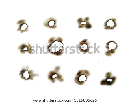 Fire holes in white paper. Collection of burnt holes in a piece of paper isolated on white background.