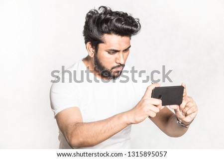 Young handsome man taking pictures on smartphone.