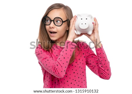 Portrait of beautiful Teen Girl in funny eye Glasses holding Piggy Bank, isolated on white background. Saving Money and childhood concept.