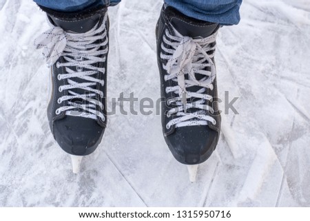 Man's hockey skates on ice background. People skate on the rink.