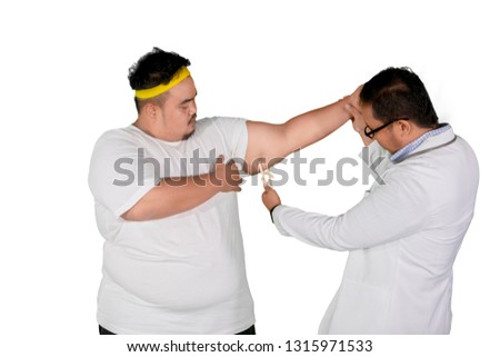 Picture of male doctor examining his fat patient by using calipers in the studio, isolated on white background