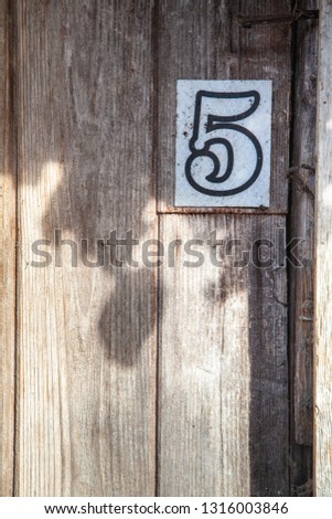 Number 5 on a wooden gate