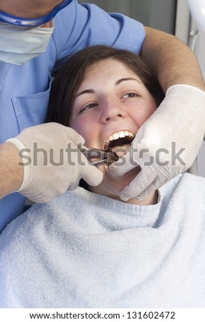 young female patient takes a dental attendance in the dentist's office.