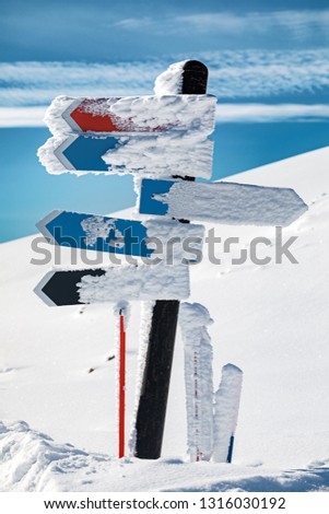 Blank arrow sign covered with snow in mountains, close up. Ski Resort at Caucasus Mountains, Rosa Khutor, Sochi, Russia