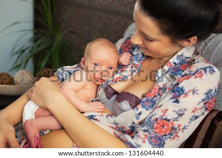 Portrait of happy attractive mother with her baby on the bed at home