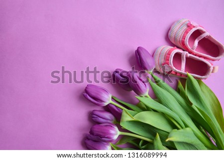 wreath tulips on a pink background and children's shoes for girls. baby shower holiday decor greeting card, floral arrangement of the newborn and new parents, celebration