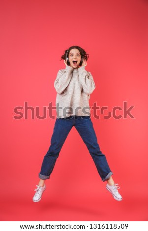 Full length portrait of a happy young woman isolated over pink background