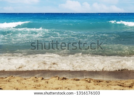 View on Sandy beach, blue sea water and clouds on sky. Background. Selective focus. 