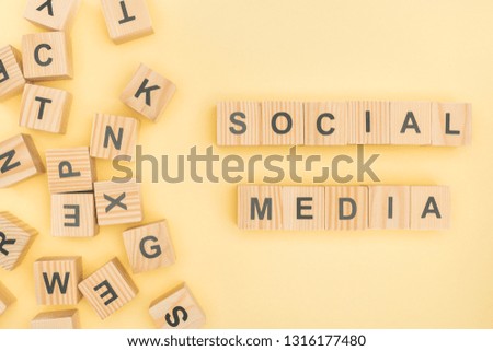 top view of social media lettering with wooden cubes on yellow background