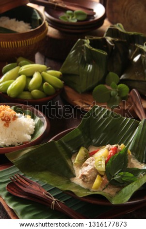 Garang Asem Ayam. Javanese dish of tangy chicken curry steamed in banana leaf pouch.