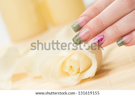 Manicure - Nice manicured woman fingernails touching rose.
