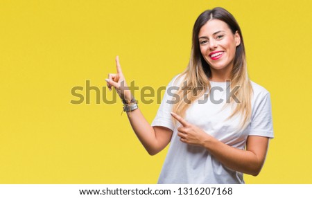 Young beautiful woman casual white t-shirt over isolated background smiling and looking at the camera pointing with two hands and fingers to the side.