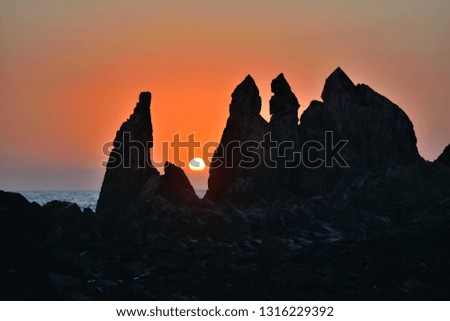 Sun setting over rocks in Arambol beach, Goa