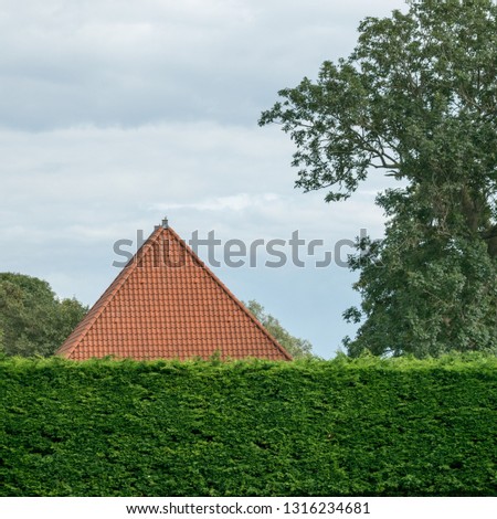 A typical example of a farm roof which is found often in the Dutch province Noord-Holland - it is pictured with a lot of green around it. The new style has roof tiles in stead of straw roofing.