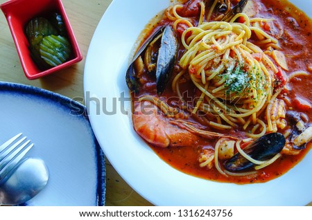 Seafood spaghetti with tomato sauce for lunch at modern restaurant.