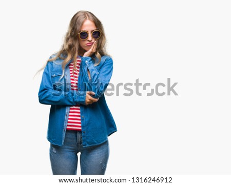 Beautiful young blonde woman wearing sunglasses over isolated background thinking looking tired and bored with depression problems with crossed arms.