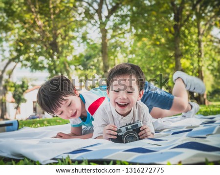little kids boy enjoying learning professional photographer taking a picture using a vintage retro film in nature park ,People lifestyle concept.