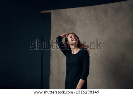 beautiful woman model on gray fabric background in dark clothes
