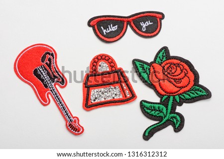 Set of red embroidered patches isolated on white. Guitar, bag, sunglasses and rose. Decorative elements for denim.