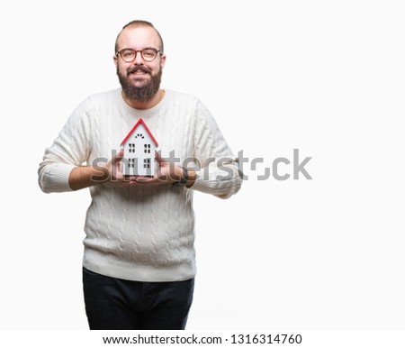 Young caucasian real state agent man holding house isolated background with a happy face standing and smiling with a confident smile showing teeth