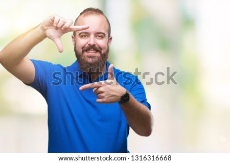 Young caucasian hipster man wearing blue shirt over isolated background smiling making frame with hands and fingers with happy face. Creativity and photography concept.