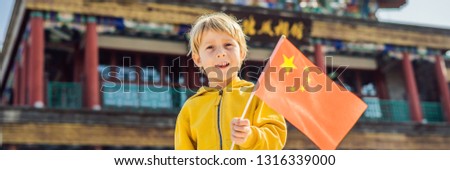 Enjoying vacation in China. Young boy with national chinese flag on the background of the old Chinese street. Travel to China concept. Visa free transit 72 hours, 144 hours in China BANNER, LONG