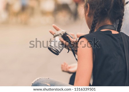Mom teaches her daughter to taking pictures. Selective focus on hand.