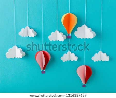 Blue background paper with white clouds on a string and balloons, minimalism, decor for postcard, multicolored