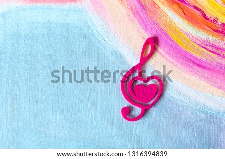 Treble clef with a heart on a beautiful background.Treble clef with a heart on a beautiful background.Photo background to Valentine's Day. Acrylic painting.