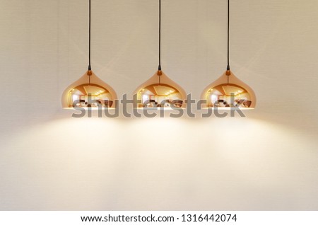 modern gold lamp with soft light on a beige background textured wall Royalty-Free Stock Photo #1316442074