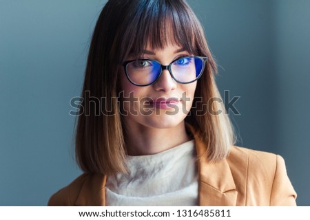 Portrait of beautiful young woman wearing eyeglasses in office