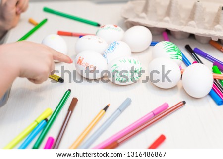 A child will paint Easter eggs with felt-tip pens. Easter ideas. Space for text. Egg tray. Happy easter.