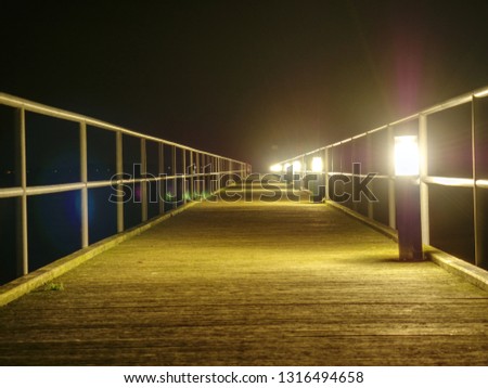Wooden terrace mole or pier early morning. View of wooden bridge above smooth ocean. Perspective of wooden pier in dock
