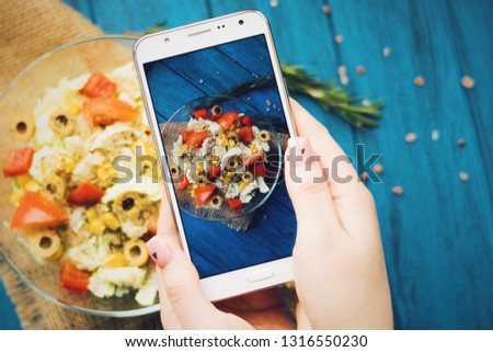 Female hands taking a photo of vegetable salad with mobile phone. Healthy food. Vegan salad. Smb making a photo of food with mobile phone.