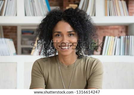 Smiling young african american female student or online teacher tutor looking at camera webcam making distance video conference call for job interview, happy black woman record vlog, close up portrait