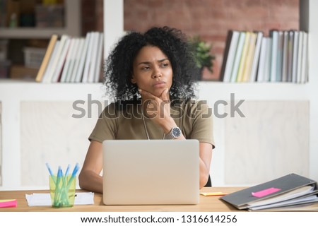 Thoughtful concerned african american female worker student feeling uncertain bored doubtful solving problem at work with laptop, puzzled black businesswoman looking away thinking having lack of idea Royalty-Free Stock Photo #1316614256