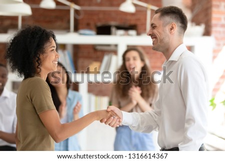 Happy african female intern worker getting hired promoted handshaking caucasian boss congratulating successful black employee by shaking clapping hand give reward bonus, gratitude recognition concept Royalty-Free Stock Photo #1316614367