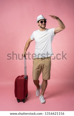 Man traveler with suitcase, passport and ticket on color background