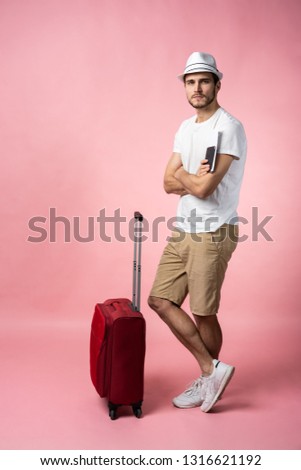 Man traveler with suitcase, passport and ticket on color background