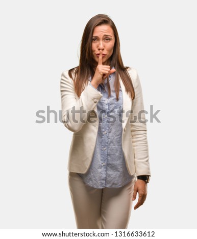 Caucasian business young woman keeping a secret or asking for silence