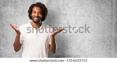 Handsome african american surprised and shocked, looking with wide eyes, excited by an offer or by a new job, win concept