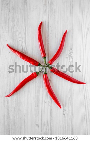 Hot red chili peppers on a white wooden surface. From above, top view, flat lay. Close-up.