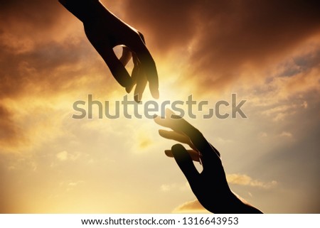 silhouette of human hands on sunset.Trust and help concept.