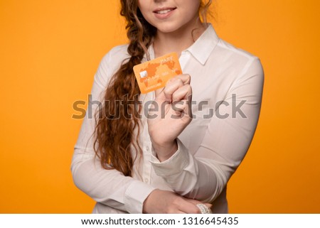Picture of a girl holding orange credit card