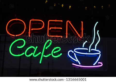 neon sign in window of Cafe coffee shop red and green letter blue and purple steaming cup of coffee icon