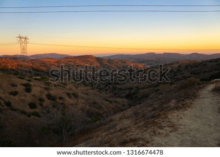 rolling hills at sunset with power lines