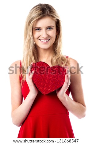 Beautiful young girl holding heart shaped gift.