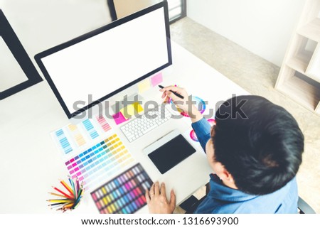 Graphic designer drawing on graphics tablet at workplace