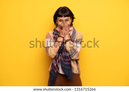 Young hippie woman over yellow wall smiling a lot